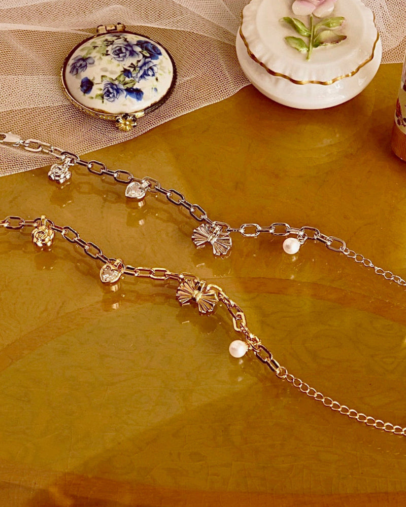 Gold chain bracelet with floral and pearl charms 